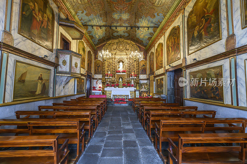 15世纪Nossa Senhora da concep<e:1>礼拜堂的内部中庭和长椅，或圣母教堂，位于葡萄牙卡马拉德洛博斯海滨渔村的历史老城区，位于非洲海岸外的马德拉加那利群岛。